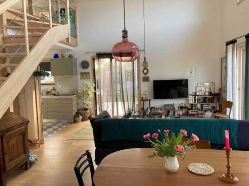 sala de estar con sofá verde y mesa en Belle villa neuve bioclimatique proche plages golf, en Seignosse