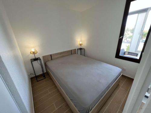 ein großes Bett in einem Zimmer mit Fenster in der Unterkunft Appartement Valras-Plage, 2 pièces, 4 personnes - FR-1-701-66 in Valras-Plage