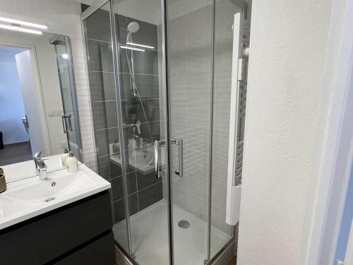 ein Bad mit einer Glasdusche und einem Waschbecken in der Unterkunft Appartement Valras-Plage, 2 pièces, 4 personnes - FR-1-701-66 in Valras-Plage