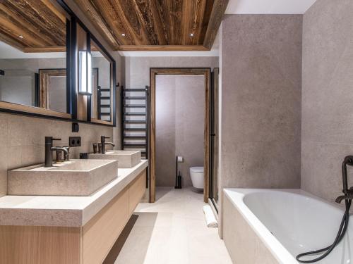 uma casa de banho com 2 lavatórios e uma banheira em Appartement Méribel, 6 pièces, 10 personnes - FR-1-613-60 em Les Allues