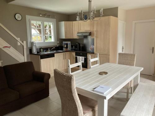 une cuisine avec une table et des chaises dans une pièce dans l'établissement Maison indépendante avec jardin près de la plage - FR-1-418-231, à Locmaria
