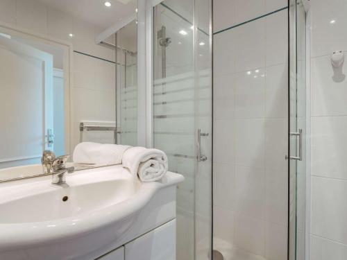 La salle de bains blanche est pourvue d'un lavabo et d'une douche. dans l'établissement Appartement La Trinité-sur-Mer, 4 pièces, 6 personnes - FR-1-477-232, à La Trinité-sur-Mer