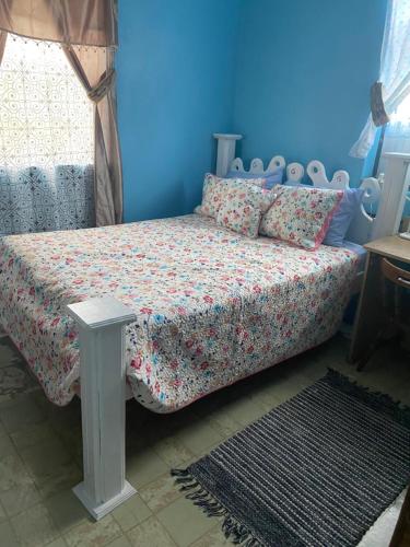 a bedroom with a bed with a blue wall at Anne's Homestay in Banse