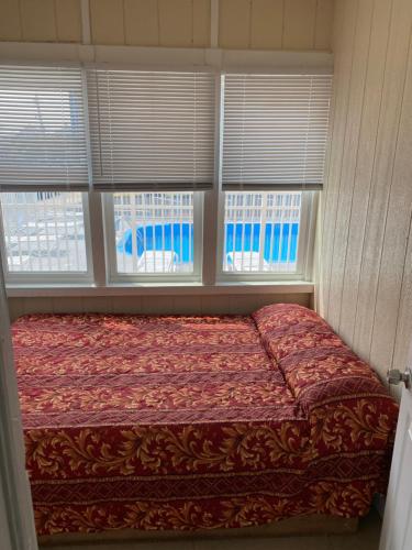 een slaapkamer met een bed en 3 ramen bij Shore Beach Houses - 38 A Lincoln Avenue in Seaside Heights
