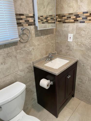 een badkamer met een wit toilet en een wastafel bij Shore Beach Houses - 38 A Lincoln Avenue in Seaside Heights