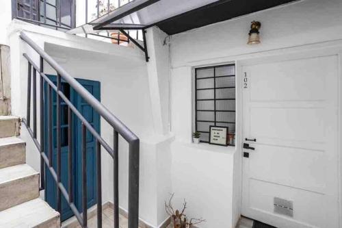ボゴタにあるGran apartamento en la Candelaria centroの青いドアと階段のある白いガレージ