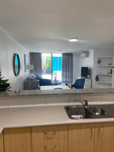 cocina con fregadero y sala de estar. en Ki-ea Apartments, en Port Macquarie