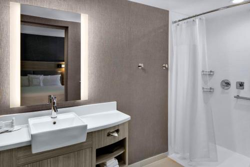 a bathroom with a sink and a mirror and a shower at SpringHill Suites Hilton Head Island in Hilton Head Island