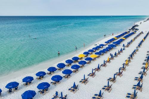 德斯坦的住宿－Pelican Beach Resort Condos，享有海滩的空中景致,配有蓝色和黄色遮阳伞