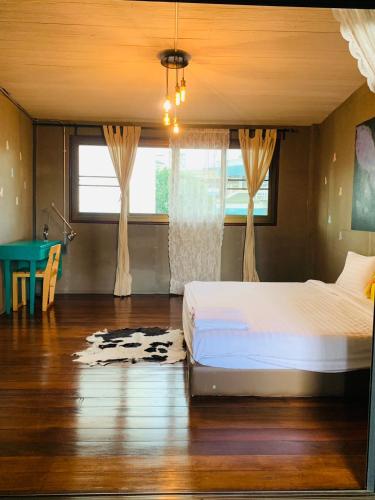 a bedroom with a bed and a table in it at Good Space Hostel in Khlong San