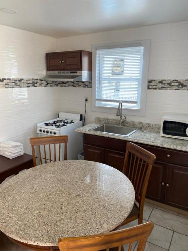 a kitchen with a table and chairs and a sink at Shore Beach Houses - 38 C Lincoln Avenue in Seaside Heights
