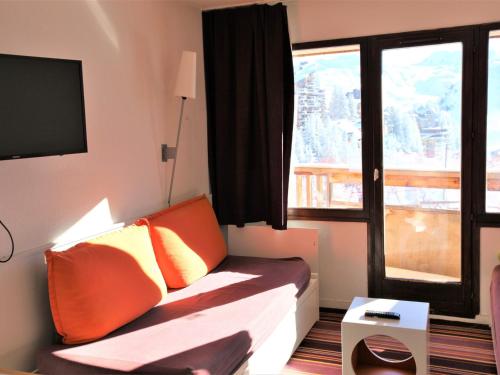 une pièce avec un canapé avec des coussins orange et une fenêtre dans l'établissement Joli 2 pièces à Avoriaz avec balcon sud, TV et WiFi - FR-1-314-185, à Avoriaz
