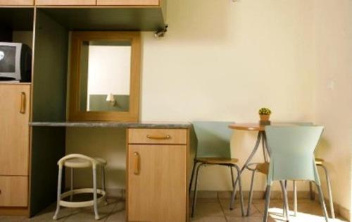 a kitchen with two chairs and a table and a counter at Villa Sofia in Skala Kefalonias