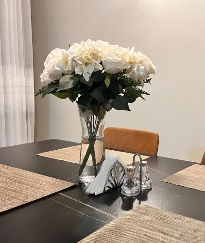 a vase of white flowers sitting on a table at Midtown Executive Suites CBD With Large Balcony in Nakuru