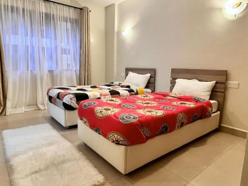 2 camas en una habitación con ventana en Midtown Executive Suites CBD With Large Balcony, en Nakuru