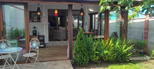 patio z krzesłami i stołem oraz roślinami w obiekcie Happy House w Kranewie