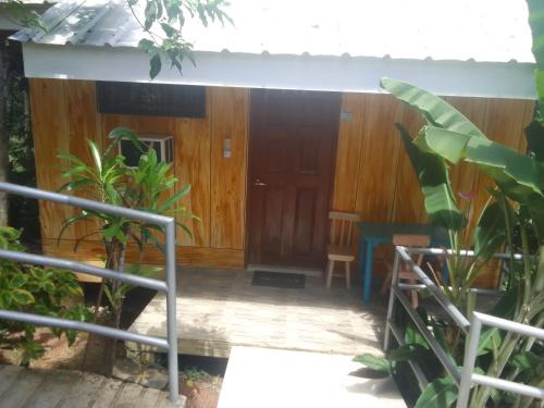 a house with a wooden door and some plants at Woodland Inn in El Nido