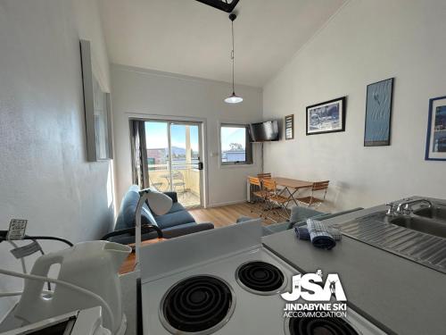 a kitchen and living room with a stove at Razorback 3 in Jindabyne