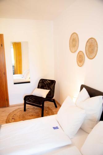 a bedroom with a bed and a chair and a mirror at Gutshof zum Wurzgarten in Hainbach