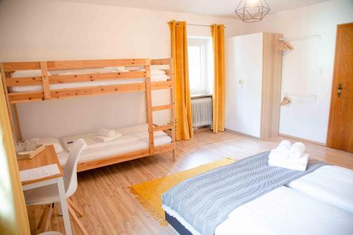 a bedroom with two bunk beds and a desk at Gutshof zum Wurzgarten in Hainbach