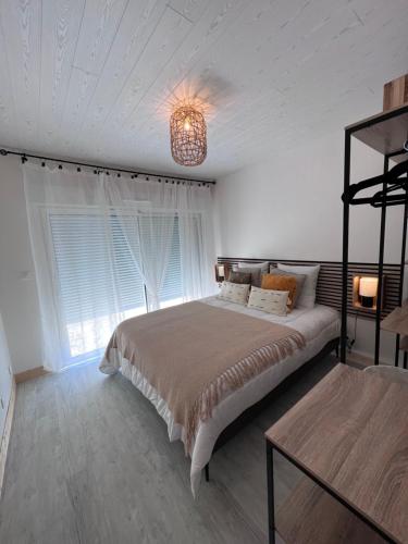 ein Schlafzimmer mit einem großen Bett und einem Kronleuchter in der Unterkunft COCOON & SPA in Médis