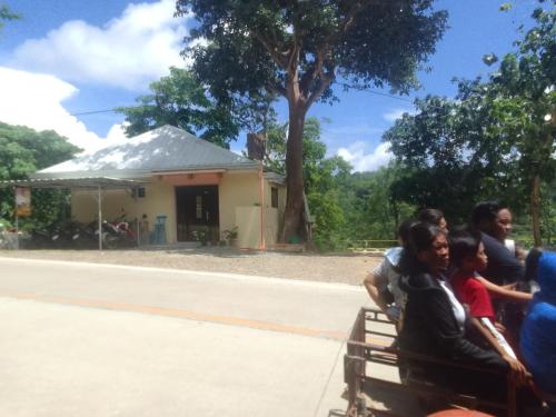 a group of people sitting on a bench in front of a building at Woodland Inn in El Nido