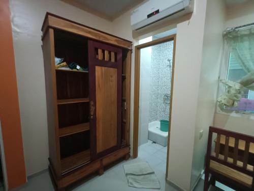 a bathroom with a wooden cabinet and a toilet at Balqies Homestay Syariah Makassar Mitra RedDoorz in Makassar