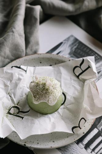 a green doughnut on a plate on a newspaper at Rarin Villas in Chiang Mai