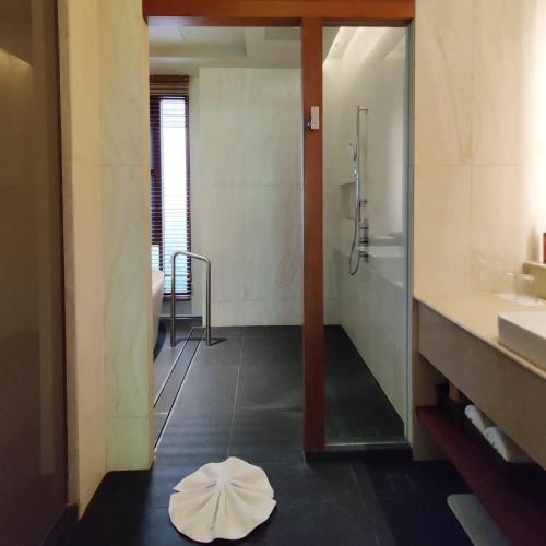 a bathroom with a shower and a white bowl on the floor at Rarin Villas in Chiang Mai