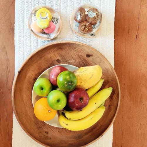 a wooden bowl of fruit on a table at Rarin Villas in Chiang Mai