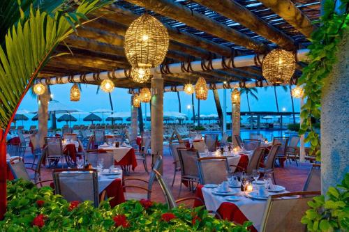 a restaurant on the beach with tables and chandeliers at Sheraton Buganvilias Puerto Vallarta in Puerto Vallarta
