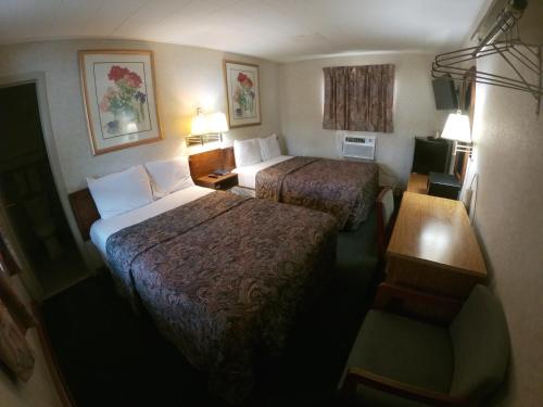 a hotel room with two beds and a table at Budget Inn Clearfield PA in Clearfield