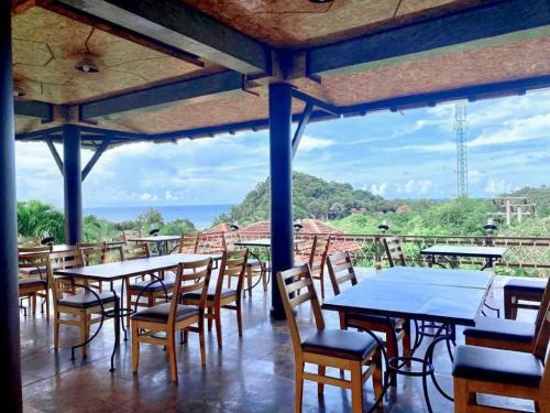 a restaurant with tables and chairs with a view at Puteri Lanta Family Villas in Ko Lanta