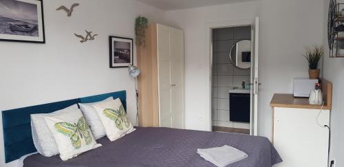 a small bedroom with a bed and a bathroom at NORTH in Jastrzębia Góra