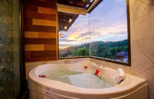 a bath tub in a bathroom with a large window at Puteri Lanta Family Villas in Ko Lanta