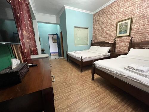 a room with two beds and a brick wall at Hualien Bay in Jian