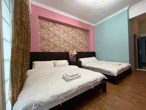 a bedroom with two beds and a brick wall at Hualien Bay in Jian