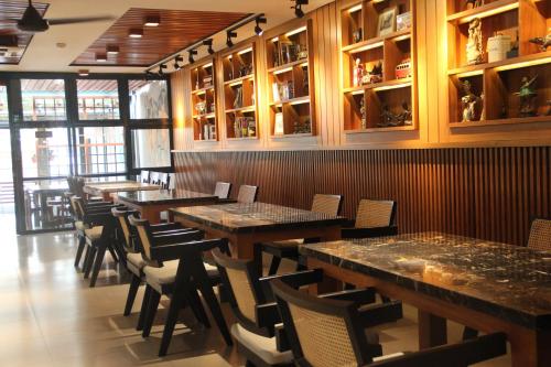 a restaurant with wooden tables and chairs in a room at Ivory Hotel Bandung in Bandung