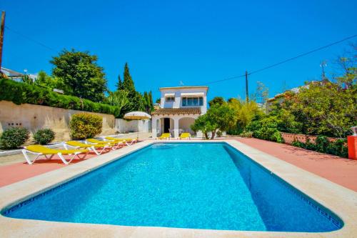 una piscina con sillas y una casa en Tere - holiday home with private swimming pool in Calpe, en Calpe