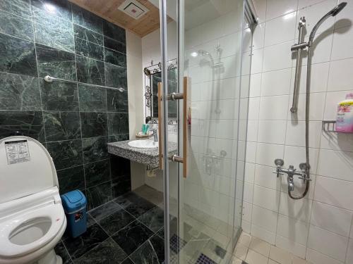 a bathroom with a toilet and a glass shower at Hualien Bay in Jian