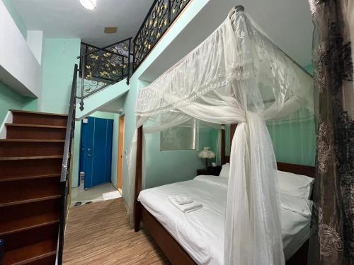 a bedroom with a canopy bed and a staircase at Hualien Bay in Ji'an