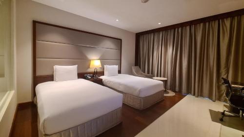 a hotel room with two beds and a window at Crowne Plaza Kochi by IHG in Cochin