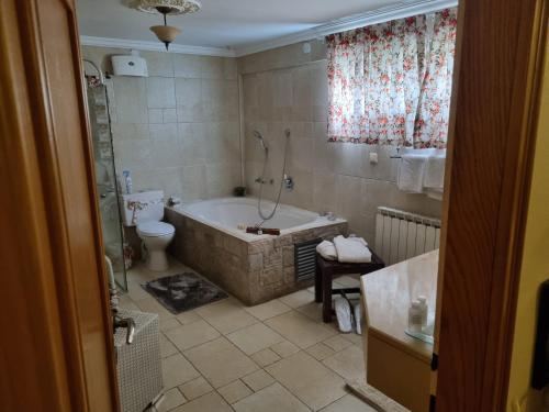 a bathroom with a tub and a toilet at Rosh Pinat Noy in Rosh Pinna