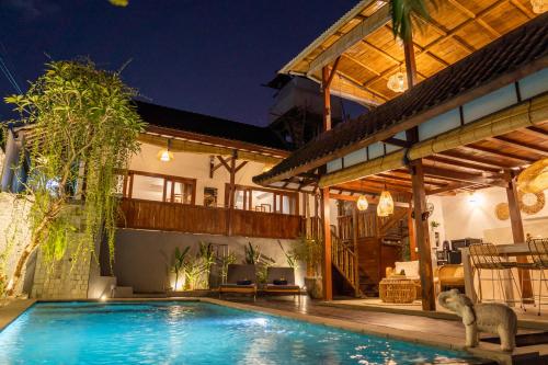 a house with a swimming pool in front of a house at Villa Innerbloom stylish 2BR with large pool & garden in Canggu