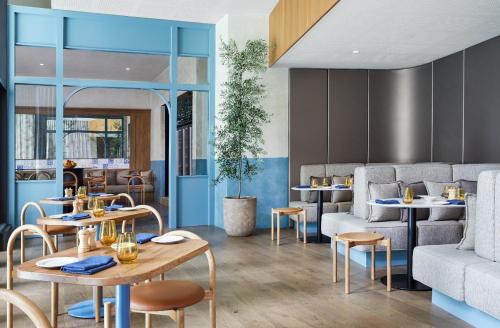 ブリスベンにあるThe Westin Brisbaneのテーブルと椅子とソファのあるレストラン