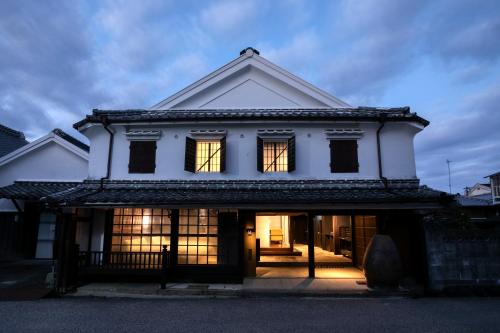 una casa blanca con sus luces encendidas en 茜さす 肥前浜宿 Akanesasu Hizenhamashuku, en Hama