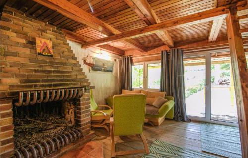 a living room with a brick fireplace and a green chair at 2 Bedroom Amazing Home In Wilimy in Wilimy