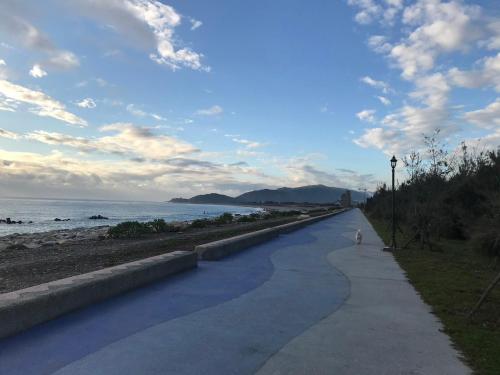 a path next to the beach with a person walking down it at Hualien Bay in Jian
