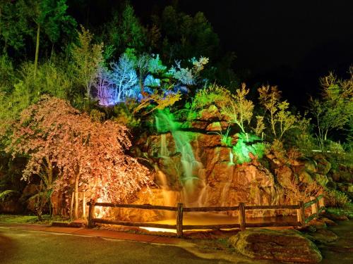 a garden at night with a waterfall and lights at Fudouonsen Sawaya in Shimojo mura