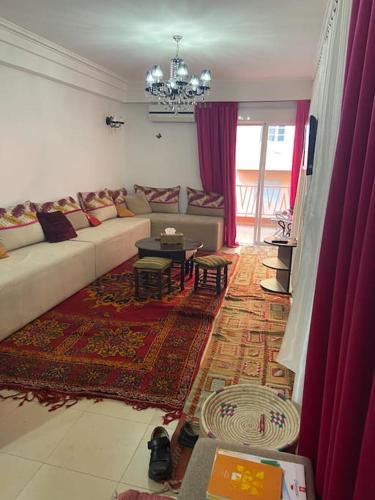 a living room with a couch and a table at appartement dans résidence Marrakech avec piscine in Marrakesh